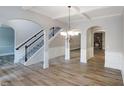 Open-concept living room with hardwood floors, arched doorways and a staircase at 2897 Austin Common Dr, Dacula, GA 30019