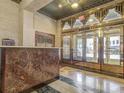 Grand lobby with a marble reception desk and brass-framed doors, reflecting the building's 1930s architectural style at 32 Peachtree Nw St # 705, Atlanta, GA 30303