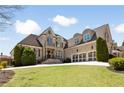 Charming brick home with lush green lawn, mature trees, and a three-car garage with carriage doors at 2770 Wooded Hills Walk, Marietta, GA 30062