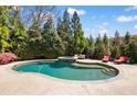 Beautiful backyard pool with mature landscaping and an inviting lounge area, perfect for relaxing and entertaining at 2770 Wooded Hills Walk, Marietta, GA 30062