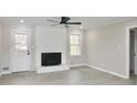 Cozy living room with brick fireplace, ceiling fan, and stylish vinyl flooring at 2447 Old Peachtree Rd, Duluth, GA 30097