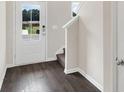 Entryway with dark wood floors, white walls, a staircase, and a view of the front door at 320 Mahone Dr, Lilburn, GA 30047