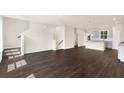 Open-concept living room with hardwood floors, a staircase, and modern finishes at 320 Mahone Dr, Lilburn, GA 30047