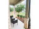 Covered porch features comfortable seating with a backyard view at 5745 Pickens Garden Ln, Powder Springs, GA 30127