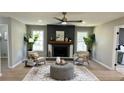 Bright living room featuring a fireplace, stylish furniture, modern lighting, and seamless hardwood floors at 2265 Hammond Ct, Ellenwood, GA 30294