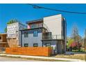 Rear elevation of this modern three-story home with a wood fence and glass-enclosed balconies at 548 Fletcher St, Atlanta, GA 30310
