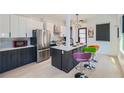 Modern kitchen featuring stainless steel appliances, an island with counter seating, and stylish white and gray cabinetry at 548 Fletcher St, Atlanta, GA 30310