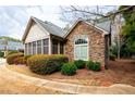 Charming home exterior featuring stone accents, manicured landscaping, and a screened porch at 120 Chastain Nw Rd # 1204, Kennesaw, GA 30144