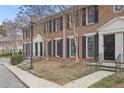 Brick townhouse with symmetrical window placement and black shutters on a landscaped lawn at 1101 Collier Nw Rd # V3, Atlanta, GA 30318