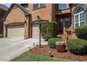 Up close view of a beautiful red brick home featuring manicured bushes and a well-maintained lawn at 6016 Southland Dr, Stone Mountain, GA 30087