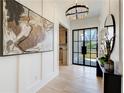 Light-filled foyer with chandelier, wall art, bench and black framed door at 555 Lower Birmingham Rd, Canton, GA 30115