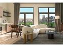 Sunlit living room with stylish sofa, dining table, and cityscape view through large windows at 567 Ponce De Leon Ne Ave # 506, Atlanta, GA 30308