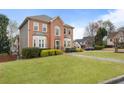 A traditional brick house with lush green lawn, manicured shrubs and inviting front porch at 2605 Jacobean Rd, Acworth, GA 30101