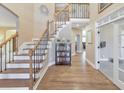 Grand foyer featuring hardwood floors, elegant staircase with wrought iron railing and neutral paint at 4073 Hickory Fairway Dr, Woodstock, GA 30188