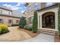Close up of the front entrance with double doors, stone steps, and manicured landscaping at 13142 Overlook Pass, Roswell, GA 30075