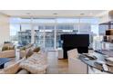 Elegant living and dining area with floor-to-ceiling windows showcasing city views, seamlessly connected to the kitchen at 45 Ivan Allen Jr Nw Blvd # 1704, Atlanta, GA 30308