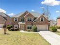 Attractive brick home boasts a well-kept lawn, mature landscaping, and a welcoming front entrance at 50 Riverstone Dr, Covington, GA 30014