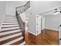 Elegant foyer showcases hardwood floors, staircase with iron spindles, and access to multiple rooms at 50 Riverstone Dr, Covington, GA 30014