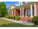 Close up on the front porch, showing red brick steps and white columns at 711 Wilhaven Ct, Loganville, GA 30052