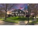 Stately home with manicured lawn, beautiful architecture and a welcoming curb appeal during sunset at 3491 Falls Branch Ct, Buford, GA 30519