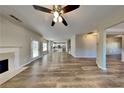 Bright, open-concept living area featuring wood-look flooring, fireplace, and ceiling fan at 4590 Carver Ct, Cumming, GA 30040