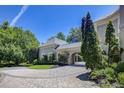 A gray home showcases a circular driveway, portico, and meticulous landscaping at 3594 Tuxedo Nw Ct, Atlanta, GA 30305