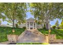 A grand home featuring stately columns, a stone staircase, and lush landscaping on a sunny day at 3594 Tuxedo Nw Ct, Atlanta, GA 30305