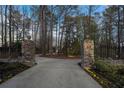 Stone gate with an address greets you as you enter the long driveway through the wooded front yard at 740 Frank Kirk Nw Rd, Kennesaw, GA 30152