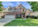 Charming two-story brick home featuring a two-car garage, manicured lawn, and classic architectural details at 106 Little Barley Ln, Grayson, GA 30017