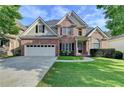 Charming two-story brick home featuring a two-car garage, manicured lawn, and classic architectural details at 106 Little Barley Ln, Grayson, GA 30017