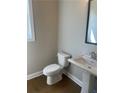 Half bathroom features a pedestal sink, mirror and hardwood floors at 274 Lakeside Pl, Canton, GA 30114