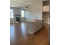 Open concept living room with a kitchen island, fireplace and hardwood floors at 274 Lakeside Pl, Canton, GA 30114