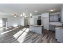 Bright, open kitchen and living area with granite island, gray cabinets, and modern fixtures at 325 Forkview Dr, Lawrenceville, GA 30044