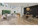 Bright open-plan living space features a cozy seating area and adjacent dining area with statement lighting fixture at 1255 E M Croy Rd, Sugar Hill, GA 30518