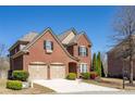 Side view of a two-story brick home with a two-car garage, set against a backdrop of mature trees at 4664 Prater Se Way, Smyrna, GA 30080