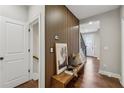 Stylish hallway with wood accent wall, hardwood floors, and a bench with decorative pillows and art at 6682 Sterling Dr, Atlanta, GA 30328