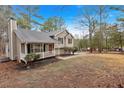 Exterior view of a tan home with a cozy front porch, nestled among mature trees at 12 Remington Ct, Euharlee, GA 30145