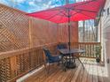 Relaxing deck area with seating, table, and a large red umbrella at 5728 Williams Rd, Norcross, GA 30093