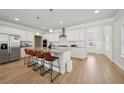 Spacious kitchen with stainless steel appliances, large island and sleek, white cabinetry at 1566 Winding Ridge Trl, Hoschton, GA 30548