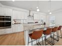 Bright kitchen boasts granite countertops, modern appliances and seating at the island at 1566 Winding Ridge Trl, Hoschton, GA 30548