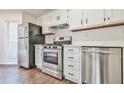 Bright kitchen featuring stainless steel appliances, white cabinetry, and dark hardware accents at 808 Riverview Se Dr, Marietta, GA 30067