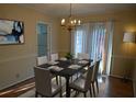 Charming dining area with a dark wood table set for six, a chandelier, and sunny window at 3338 York Pl, Decatur, GA 30032
