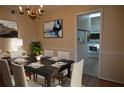 Cozy dining room featuring a dark wood table set for six, a chandelier, and view to the kitchen at 3338 York Pl, Decatur, GA 30032