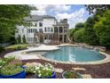 Beautiful backyard with a custom swimming pool, stone accents, covered patio, and lush greenery at 948 Saint Lyonn Cts, Marietta, GA 30068