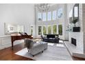 Bright living room with high ceilings, large windows, hardwood floors, fireplace, and elegant furnishings at 948 Saint Lyonn Cts, Marietta, GA 30068