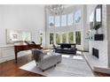 Bright living room features hardwood floors, a fireplace, a baby grand piano, and soaring windows at 948 Saint Lyonn Cts, Marietta, GA 30068