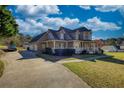 Charming two-story home with an attached garage and well-manicured lawn under a blue sky at 2002 Orchard Terrace, Loganville, GA 30052