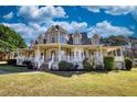 Charming two-story home with a spacious porch and well-manicured lawn under a blue sky at 2002 Orchard Terrace, Loganville, GA 30052