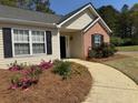 Front entrance with black shutters, brick accents, and landscaping at 4580 Darrowby Dr, Powder Springs, GA 30127