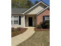 Inviting front entrance with a well-lit pathway and manicured flowerbeds at 4580 Darrowby Dr, Powder Springs, GA 30127
